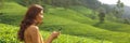 Traveler Woman With Smartphone During Her Travel on Famous Nature Landmark Tea Plantations in Sri Lanka