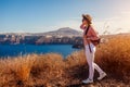 Traveler woman walking on Santorini island, Greece enjoying landscape. Happy girl enjoys Caldera view Royalty Free Stock Photo