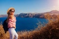 Traveler woman walking on Santorini island, Greece enjoying landscape. Happy girl enjoys Caldera view Royalty Free Stock Photo