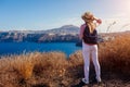 Traveler woman walking on Santorini island, Greece enjoying landscape. Happy hiker enjoys Caldera view Royalty Free Stock Photo