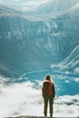 Traveler woman wander above clouds and lake in mountains