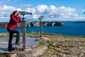 Traveler woman watching through the stationary binoculars Royalty Free Stock Photo