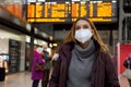 Traveler woman wearing medical face mask at the airport. Happy young woman walking and looking up with behind timetables of Royalty Free Stock Photo