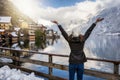 A traveler woman in winter clothing enjoys the view to the village of Hallstatt in the Austrian Alps Royalty Free Stock Photo