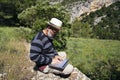 Traveler works remotely on a laptop while enjoying views of the natural mountain landscape outdoors. man working outdoors with Royalty Free Stock Photo