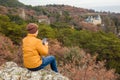 The traveler of the yellow jacket looks with the phone.