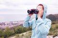 Traveler woman looking through binoculars outdoor. Royalty Free Stock Photo