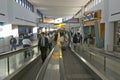 Travelers and airline industry personnel on moving sidewalks in Newark International Airport, New Jersey