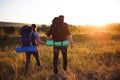 Silhouettes of two hikers with backpacks walking at sunset. Trekking and enjoying the sunset view Royalty Free Stock Photo