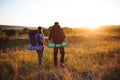Travelers with backpack walking in sunset. Silhouettes of two hikers with backpacks walking at sunset. Royalty Free Stock Photo