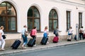Travelers carrying suitcases at old town street in Krakow, Poland