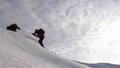 Travelers climb rope to their victory through snow uphill in a strong wind. tourists in winter work together as team