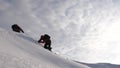 Travelers climb rope to their victory through snow uphill in a strong wind. tourists in winter work together as team