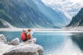 Travelers couple look at the mountain lake. Adventure and travel in the mountains region in the Austria