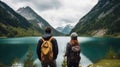 Travelers couple look at the mountain lake. Travel and active life concept with team. Adventure and travel in the mountains region Royalty Free Stock Photo