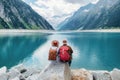 Travelers couple look at the mountain lake. Travel and active life concept with team. Royalty Free Stock Photo