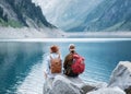 Travelers couple look at the mountain lake. Travel and active life concept with team.