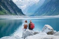 Travelers couple look at the mountain lake. Travel and active life concept with team. Royalty Free Stock Photo