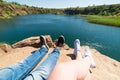 Travelers couple in sports shoes on a mountain near a river in the background of nature. Man and woman. A couple sits and makes th Royalty Free Stock Photo