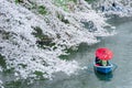 Travelers enjoying the scenario surrounded by Chidori-ga-fuchi Moat`s cherry blossoms sakura on a rental boat ride Royalty Free Stock Photo