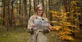 Travelers explore the mountainous forest map. Happy woman hiking and looking at map outdoors in nature. Royalty Free Stock Photo