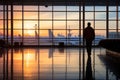 Travelers inside terminal as they watch planes. Silhouette of airline passengers in airport lounge Royalty Free Stock Photo