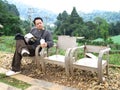 Travelers and photographer thai men travel visit and sitting rest relaxon wooden chair at outdoor garden of countryside rural at