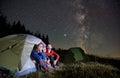 Travelers sitting in camp tent under night starry sky. Royalty Free Stock Photo