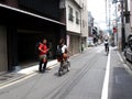 Travelers thai man backpacker walking travel visit and life lifestyle of japanese people ride bike bicycle in small alley street