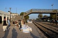 Travelers and traders wait with goods at train station platform Mirpurkhas Sindh Pakistan