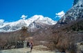 Travelers walking on walkway with snow-capped mountains to Milk Lake in Yading Nature Reserve, Sichuan, China