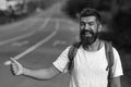 Traveling by autostop, having summer trip. Autostop travel. Man with strict face and beard travelling by hitchhiking