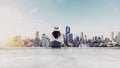 Traveling in Bangkok city, Thailand. Young traveler in white hat and cloth looking at Bangkok city view from roof top in sunrise