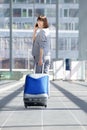 Traveling business woman walking with bag and mobile phone Royalty Free Stock Photo