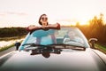 Traveling by car - couplr in love dgo by cabriolet car in sunset Royalty Free Stock Photo