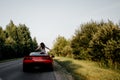 Traveling by car - happy couple in love go by cabriolet car in sunset time Royalty Free Stock Photo