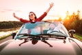 Traveling by car - happy couple in love go by cabriolet car in sunset time Royalty Free Stock Photo