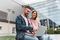 Traveling. Couple using laptop, waiting transport near airport Royalty Free Stock Photo