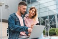 Traveling. Couple using laptop, waiting transport near airport Royalty Free Stock Photo