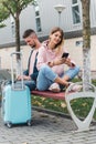 Traveling. Couple using laptop, waiting transport near airport Royalty Free Stock Photo
