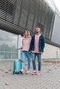 Traveling. Couple using laptop, waiting transport near airport Royalty Free Stock Photo