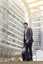 Traveling guy wearing smart casual style walking away with his luggage. Royalty Free Stock Photo