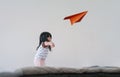 Traveling for Kids or Imagination Concept. Happy and Excited Three Years old Girl Raise Up Hand and Throw a Paper Plane in White