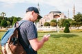 A traveling man with a backpack in Sultanahmet Square near the famous Aya Sofia mosque in Istanbul in Turkey. He looks Royalty Free Stock Photo