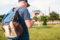 A traveling man with a backpack in Sultanahmet Square near the famous Aya Sofia mosque in Istanbul in Turkey. He looks Royalty Free Stock Photo
