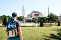 A traveling man with a backpack in Sultanahmet Square near the famous Aya Sofia mosque in Istanbul in Turkey