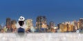 Traveling at night in the city. Young woman in white hat sitting on patio looking at Osaka city at night Royalty Free Stock Photo