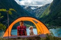 Traveling Norway, Young woman sits in the tent with her dog enjoying Beautiful view of Buerdalen Valley and Sandvevatnet Lake