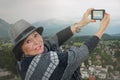 Traveling old woman shooting snow-capped mountain top