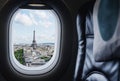 Traveling Paris, France famous landmark and travel destination in Europe. Aerial view Eiffel Tower through airplane window